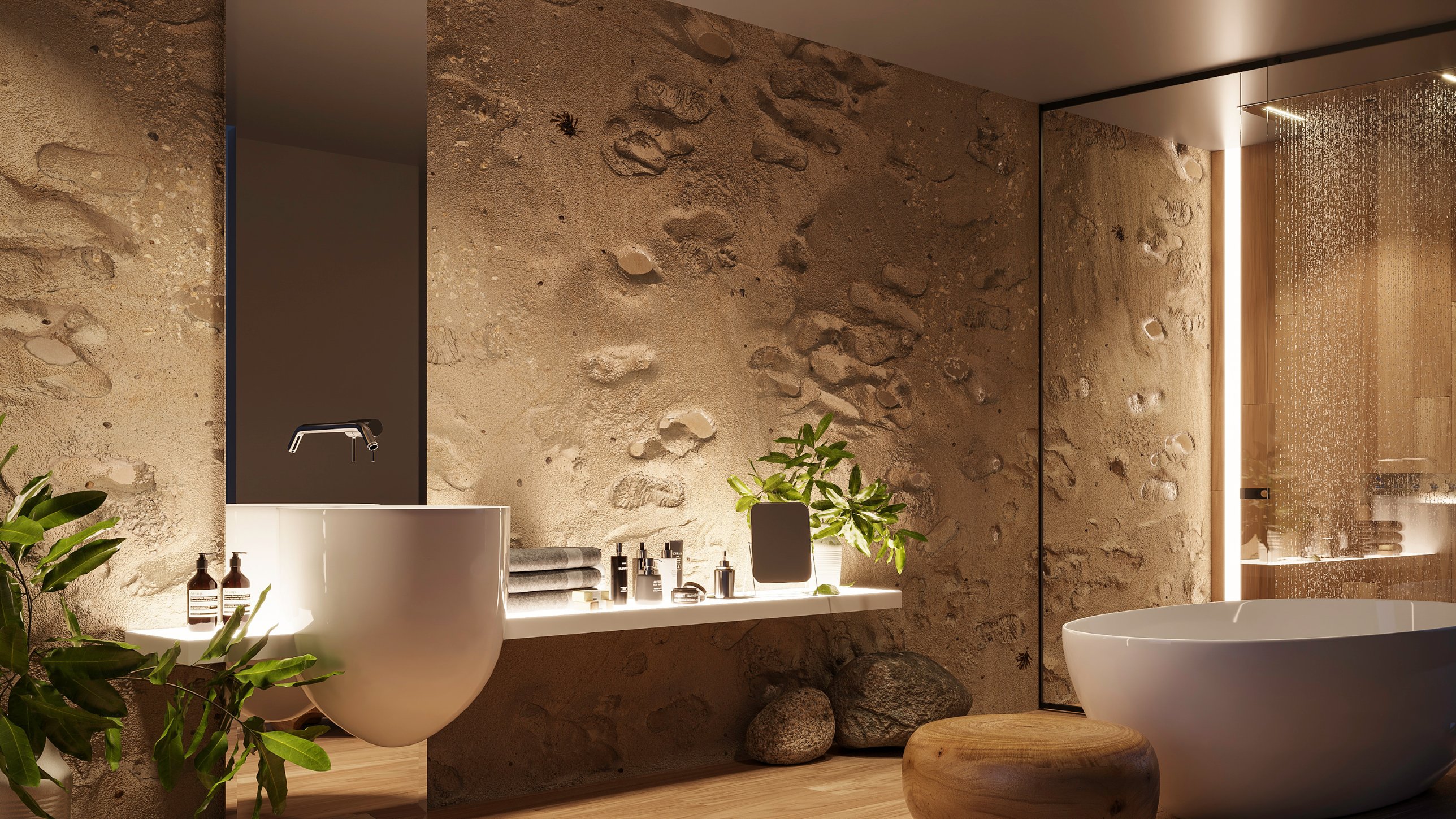 A bathroom with sand walls set with stones, a white basin and freestanding bath