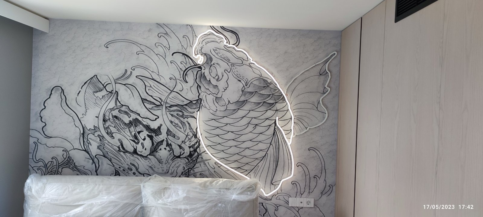 The tattoo-inspired koi mural with its glowing outline, lit for the first time