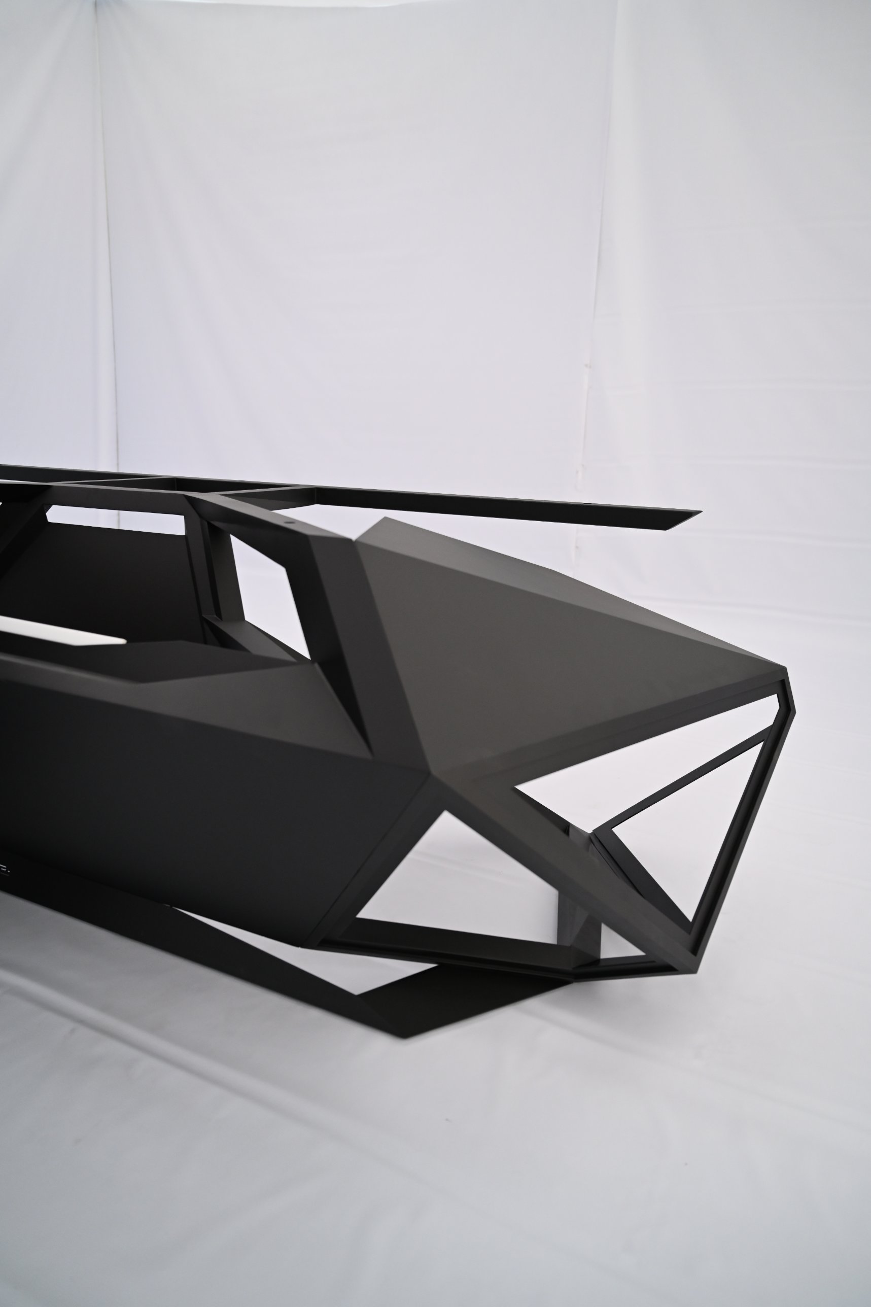 The finished desk in matte black, seen from its faceted end